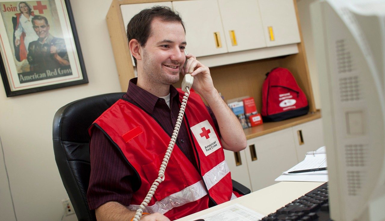Red Cross volunteer speaking on phone.