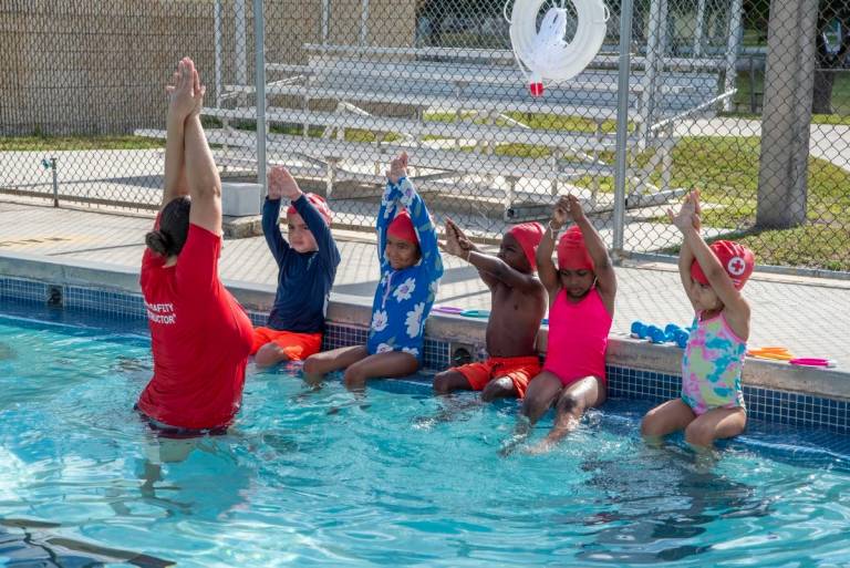 Young swimmers in a pool taking a swim lesson