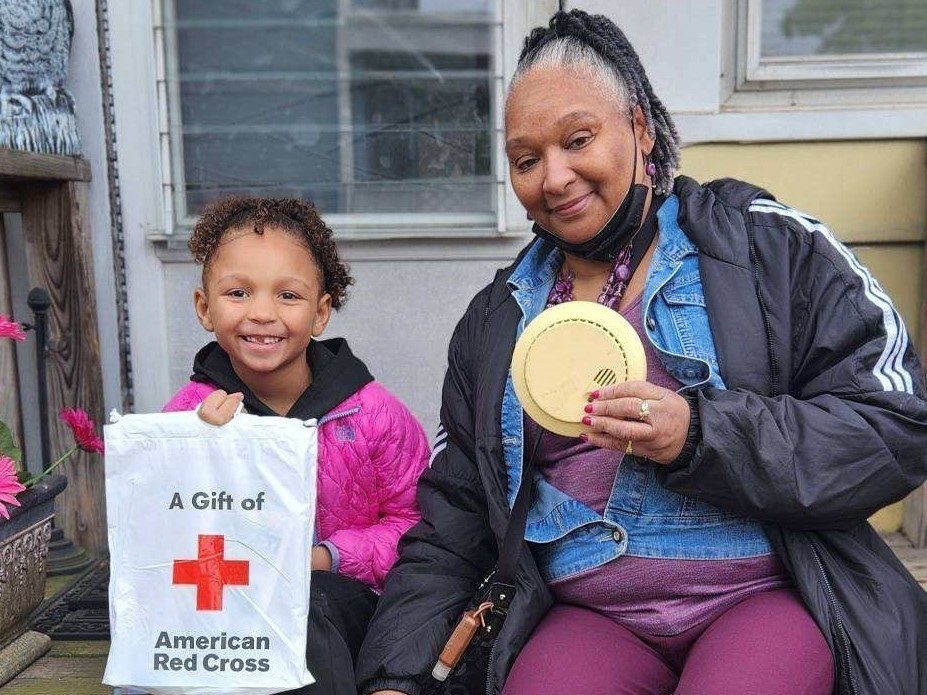 A homeowner and her granddaughter holding a new smoke alarm