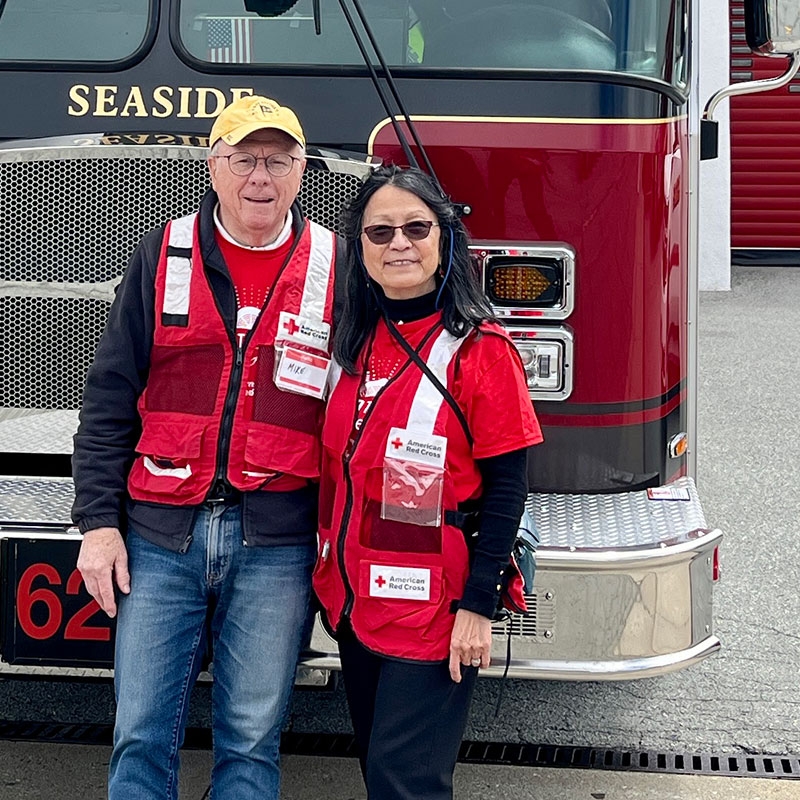 Gloria Ipson and Red Cross volunteer standing in front of fire engine.
