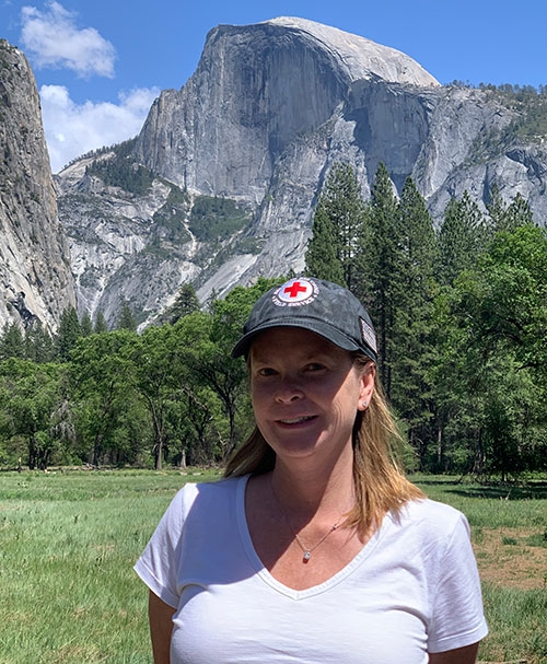 Megan Erk headshot outdoors with mountain in the background.