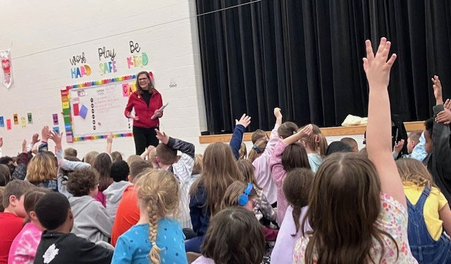 Red Cross volunteer teaching class of children